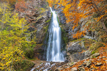 The Sutovsky waterfall in The Mala Fatra national park in Slovakia, Europe. Autumn Waterfall: Cascading water plunges down a rocky cliff surrounded by vibrant fall foliage.