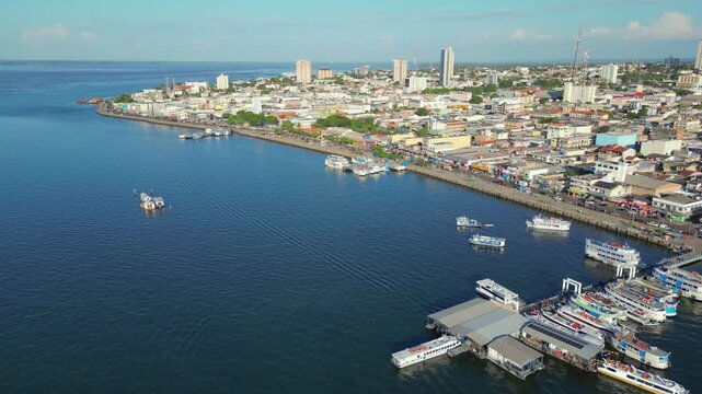 Aerial drone video of Santarem, Para, Brazil, located on the banks of the Tapajos river, showing boats docked at piers along the waterfront and the city&rsquo;s historic and commercial center