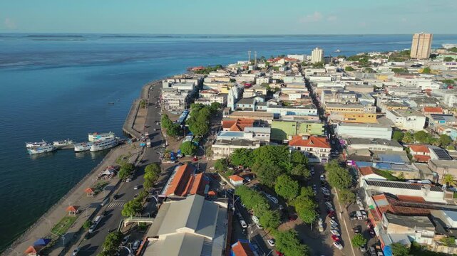 Aerial drone video of Santarem, Para, Brazil, located on the banks of the Tapajos river, showing boats docked at piers along the waterfront and the city&rsquo;s historic and commercial center
