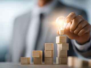 Business consulting services concept. Consultant giving advice on management. Businessman stacking wooden blocks. Lightbulb icon and lens flare light.