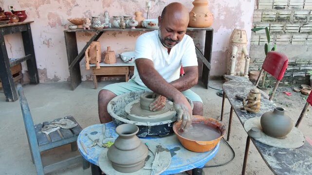 Afro-Brazilian man, third generation of a family of potters, crafting clay pieces inspired by ancient Tapajonic art to preserve cultural tradition in Santarem, Para, Brazil