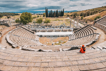 Tourist admiring the ancient Asklepion Theatre in Pergamon, Turkey, a world heritage site, showing...