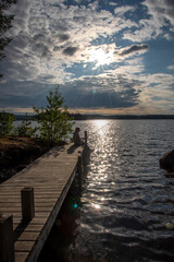 Woman fishing on the pier at lake Saimaa in Finland