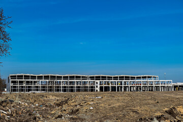 A large unfinished building with a skeletal structure indicating that it is still under construction