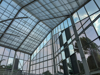 wide interior shot of a modern greenhouse, showcasing its intricate glass and metal grid structure....