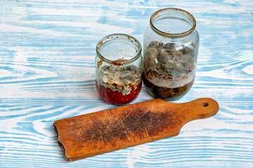 This image shows three jars with different contents on a table with a blue and white patterned...