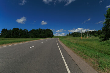 Naklejka premium The road on a summer day. Beautiful landscape, road markings, roadsides and road lines.