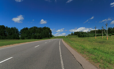 Road view on a summer day. Highways and cars, roadside and white road line markings.