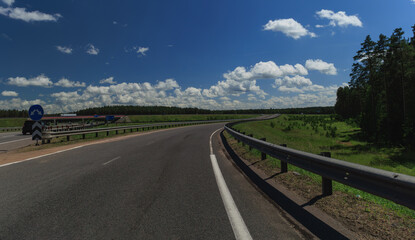 Road view on a summer day. Highways and cars, roadside and white road line markings.