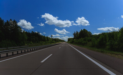 Road view on a summer day. Highways and bridge, roadside and white road line markings.