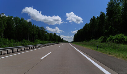 Road view on a summer day. Highways and bridge, roadside and white road line markings.