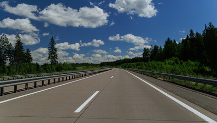Road view on a summer day. Highways and cars, roadside and white road line markings.