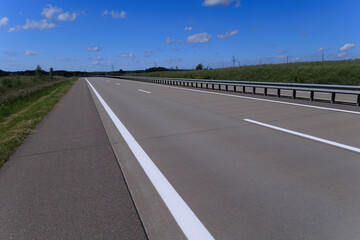 Road view on a summer day. Highways and bridge, roadside and white road line markings.