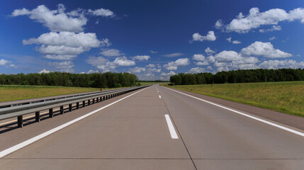 Fototapeta premium Road view on a summer day. Highways and cars, roadside and white road line markings.