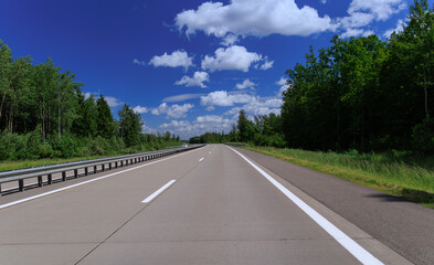 Road view on a summer day. Highways and cars, roadside and white road line markings.