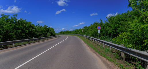 Road view on a summer day. Highways and cars, roadside and white road line markings.