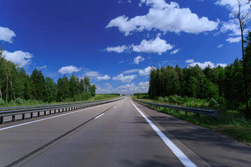 Road view on a summer day. Highways and bridge, roadside and white road line markings.
