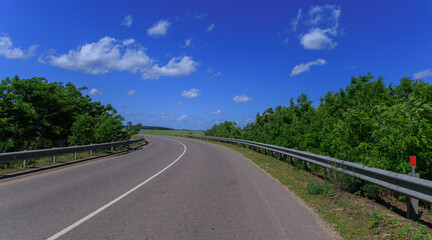 Road view on a summer day. Highways and cars, roadside and white road line markings.