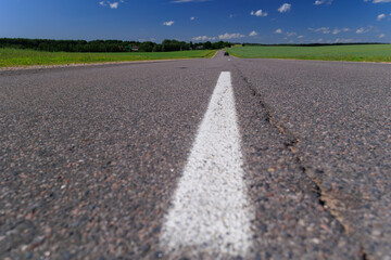 Fototapeta premium Road view on a summer day. Highways and cars, roadside and white road line markings.