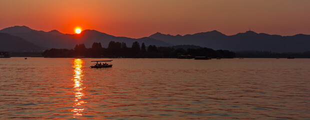 Panorama of a red and orange sunset over West Lake in Hangzhou, China