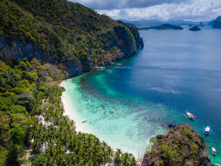 Fototapeta premium Seven commandos beach in El Nido, Palawan, Philippines islands. Aerial drone view. Top view of beautiful turquoise beach, with white sand and palms