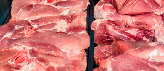 Freshly prepared pork cuts displayed at a local market in the afternoon light, showcasing various portions ready for customer selection