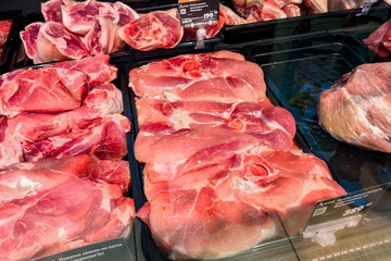 Freshly prepared pork cuts displayed at a local market in the afternoon light, showcasing various...