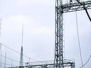 Steel transmission towers support electrical grid in overcast weather during early morning hours at...