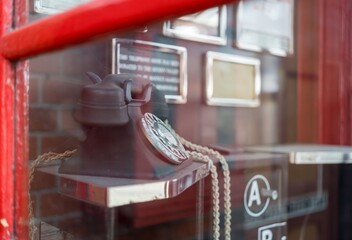 Vintage rotary telephone inside a classic red British phone box.