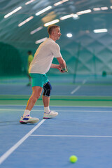 Obraz premium Man playing tennis on a court