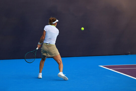 Female tennis player hitting a forehand shot on outdoor court