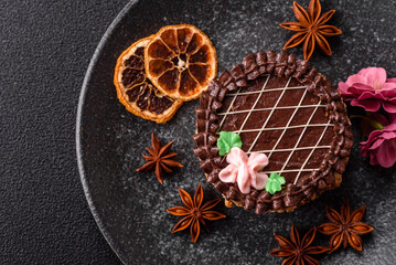 Sweet tart, pie with chocolate and cream with fruit filling on a plate. Chocolate tart