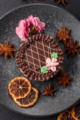 Sweet tart, pie with chocolate and cream with fruit filling on a plate. Chocolate tart