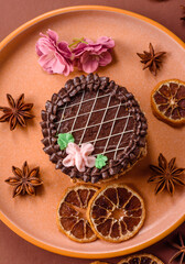 Sweet tart, pie with chocolate and cream with fruit filling on a plate. Chocolate tart