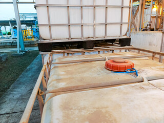 Industrial liquid containers at a chemical plant demonstrate material handling for manufacturing...