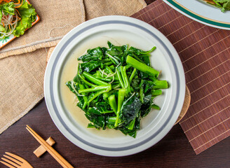 Fresh Stir Fried Chinese Kale with Garlic in Oyster Sauce Served on White Plate, Top View of Asian Cuisine