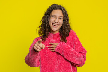 Caucasian girl pointing finger to camera, laughing out loud, taunting making fun of ridiculous appearance, funny joke anecdote, bullying, abuse. Young teen child isolated on yellow background indoors