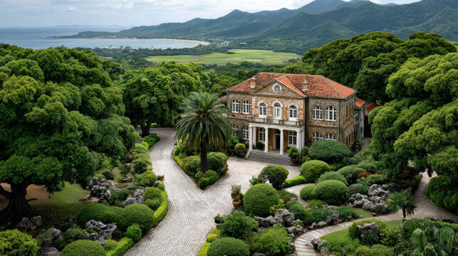 Elegant mansion surrounded by lush greenery and winding path with scenic mountain views