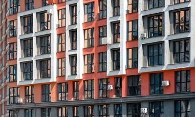 Obraz premium Close up of modern urban tower. Tall multi storey residential building with glass windows and