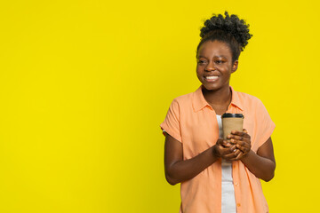 African American woman holds a plastic cup of coffee, happy of its aroma and taste with a satisfied...