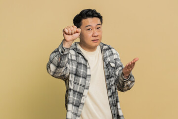 Knock-knock who is there. Confused excited Asian man knocking door gesture asking who is at home,...