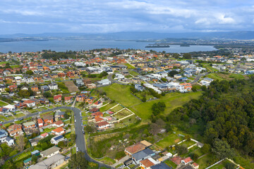 Drone aerial photograph of the town of Lake Heights with Lake Illawarra in the background in the greater Wollongong region of the Illawarra district on the south coast of New South Wales, Australia. 