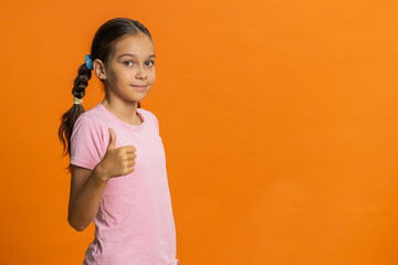 Like. Happy young preteen child girl kid looking approvingly at camera showing thumbs up, like sign...