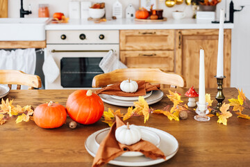 Cozy autumn kitchen decorated for Thanksgiving dinner with pumpkins and fall leaves