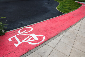 Brightly colored bike lane alongside a winding pathway in an urban setting during daytime