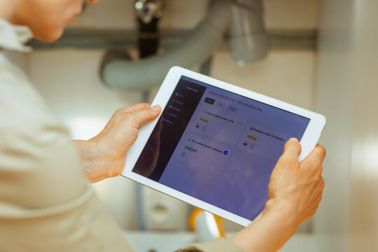 Person reviews plumbing tasks on a tablet, including pipe inspection and valve replacement, suggesting home maintenance and repair planning.