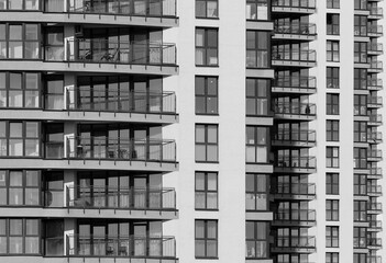 Geometric pattern of multiple glass windows on tall multistory residential block in metropolitan