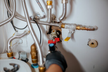 Gloved Hand Operating a Red Water Valve