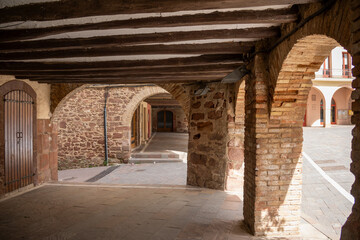 Main square of Prades, a charming village in Baix Camp, Tarragona, Catalonia, Spain, known as the “Red Town” for its distinctive reddish sandstone buildings.