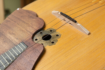 Detailed close up of a traditional domra string instrument showing the strings, bridge, and wooden...